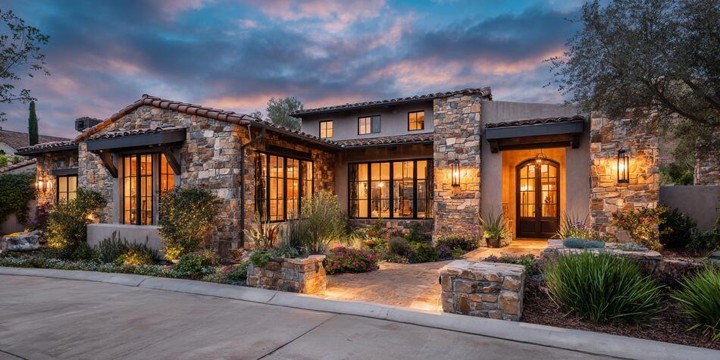 Ranch style home exterior with stone accents and custom Rancho Santa Margarita CA replacement windows glowing at dusk.
