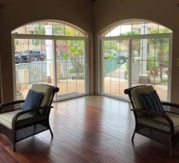 Interior living room featuring Irvine, CA replacement windows with arched glass and patio views