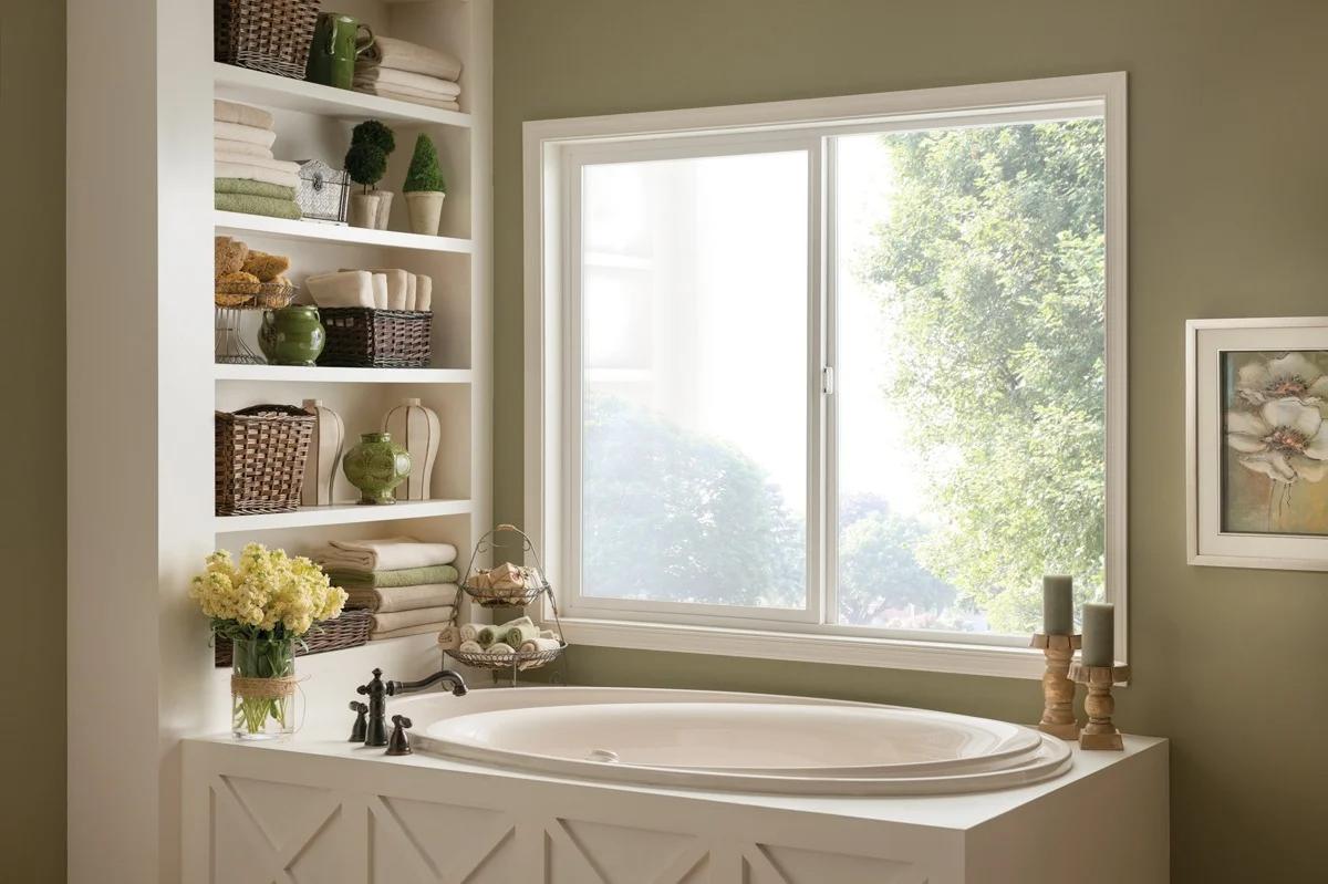 Serene bathroom with a soaking tub and large white sliding window overlooking greenery, demonstrating bright interiors and energy-efficient Replacement Windows Trabuco Canyon, CA.