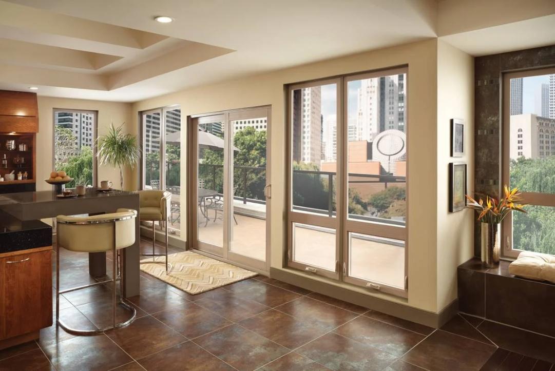Spacious modern living area with large floor-to-ceiling windows and sliding glass doors opening to a balcony, highlighting expansive views and energy-efficient Replacement Windows Trabuco Canyon, CA.