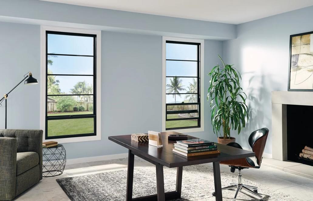 Modern home office with two large black-framed windows bringing in natural light and outdoor views, showcasing stylish and energy-efficient Replacement Windows Trabuco Canyon, CA.